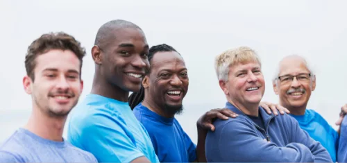 A bright group of men smiling together in a recovery community